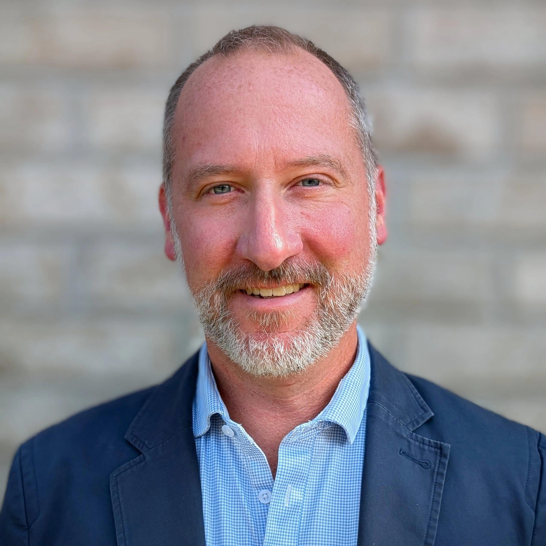 photo of male professor with short hair and beard with blue suit coat and button down shirt